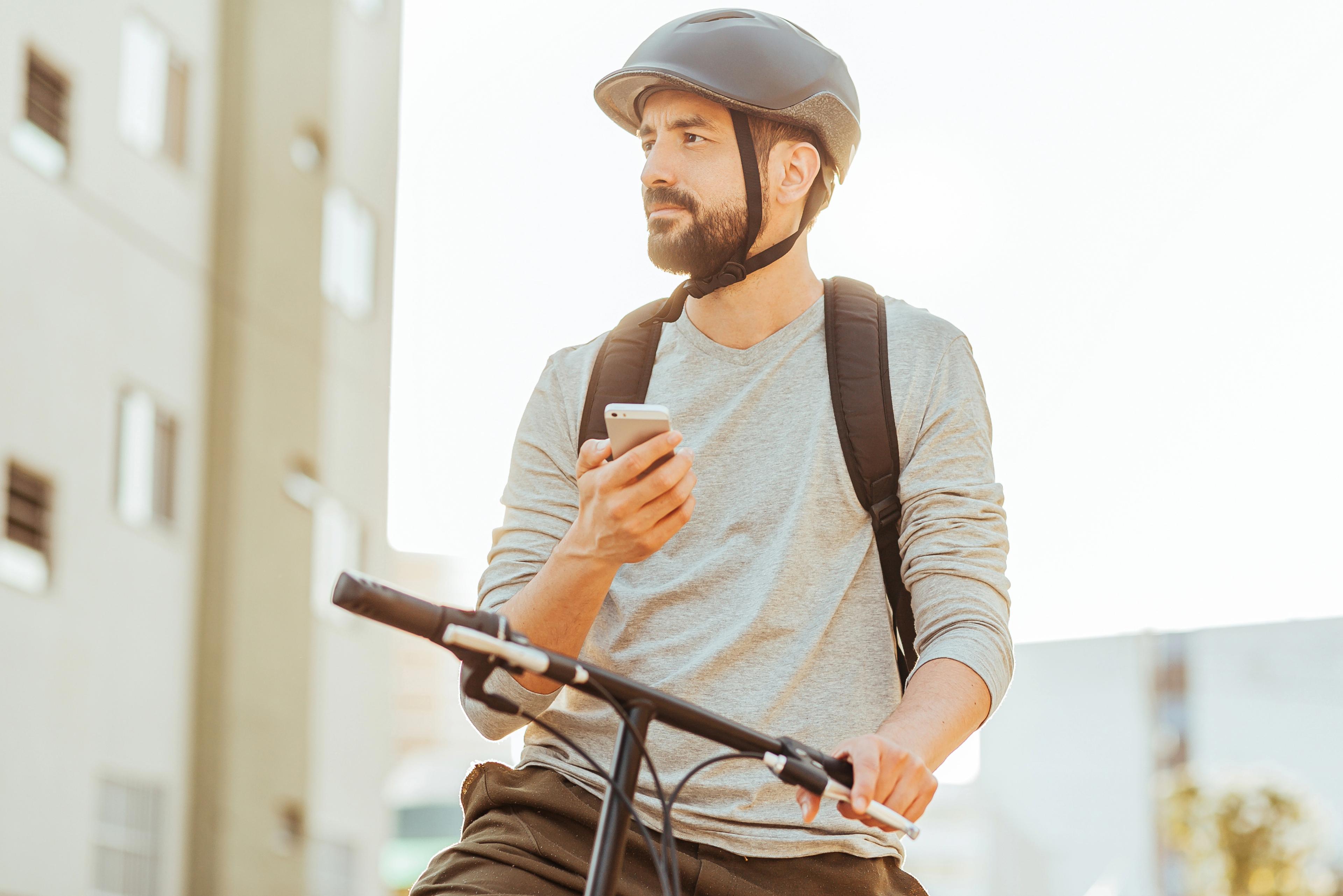 Man on a bicycle using a smartphone for navigation, powered by the Galileo programme